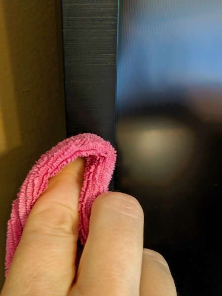 cleaning the tv screen with a microfiber cloth