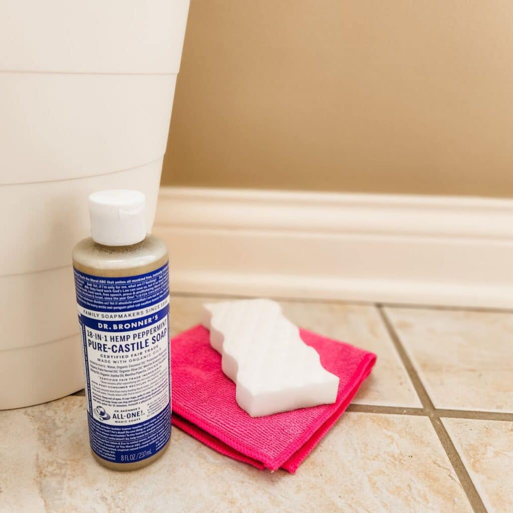 soap, a microfiber, and a magic eraser sitting next to the baseboards.