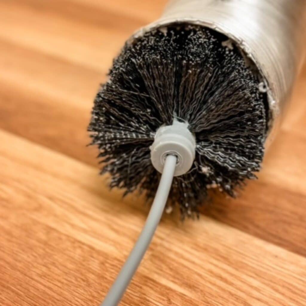 using a dryer brush to clean out dryer vent duct